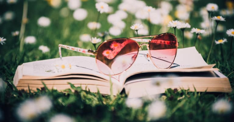 Livre sur herbe avec lunettes roses